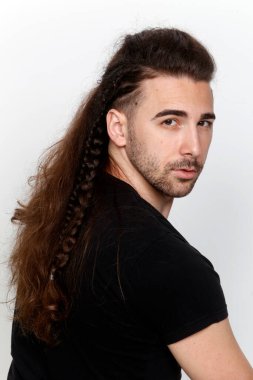 İzole edilmiş arka planda saç örgüleri olan şık bir erkek model. Tarz, saç stili, moda konsepti.
