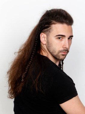 İzole edilmiş arka planda saç örgüleri olan şık bir erkek model. Tarz, saç stili, moda konsepti.