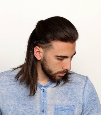 İzole edilmiş arka planda saç örgüleri olan şık bir erkek model. Tarz, trendler, saç stili, moda kavramı.