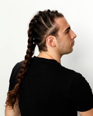 İzole edilmiş arka planda saç örgüleri olan şık bir erkek model. Tarz, saç stili, moda konsepti.