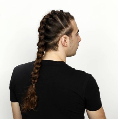 İzole edilmiş arka planda saç örgüleri olan şık bir erkek model. Tarz, saç stili, moda konsepti.