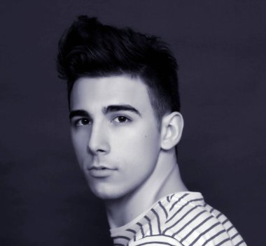 Çekici erkek model, kısa saçlı, izole edilmiş arka planda poz veriyor. Tarz, trendler, moda konsepti.