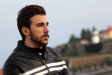 Açık havada poz veren kısa saçlı çekici erkek model. Tarz, trendler, moda konsepti.