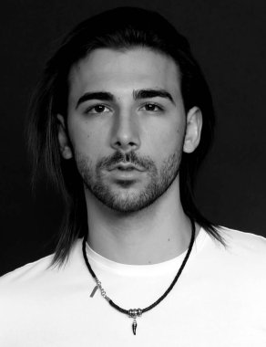 Uzun saçlı ve sakallı çekici erkek model izole bir arka planda stüdyoda poz veriyor. Tarz, trendler, moda konsepti.