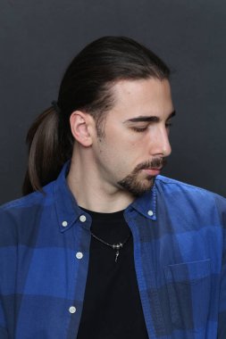 Uzun saçlı ve sakallı çekici erkek model izole bir arka planda stüdyoda poz veriyor. Tarz, trendler, moda konsepti.