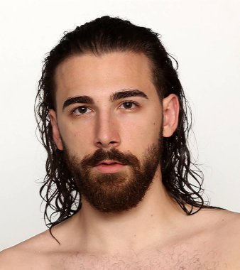 Uzun saçlı ve sakallı çekici erkek model izole bir arka planda stüdyoda poz veriyor. Tarz, trendler, moda konsepti.