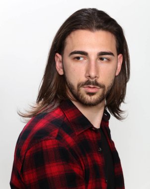 Uzun saçlı ve sakallı çekici erkek model izole bir arka planda stüdyoda poz veriyor. Tarz, trendler, moda konsepti.