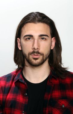 Uzun saçlı ve sakallı çekici erkek model izole bir arka planda stüdyoda poz veriyor. Tarz, trendler, moda konsepti.