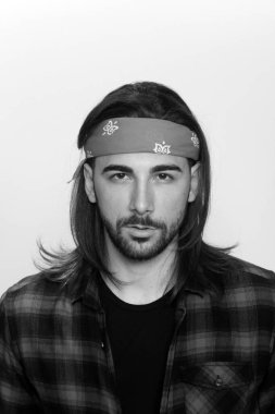 Uzun saçlı ve sakallı çekici erkek model izole bir arka planda stüdyoda poz veriyor. Tarz, trendler, moda konsepti.