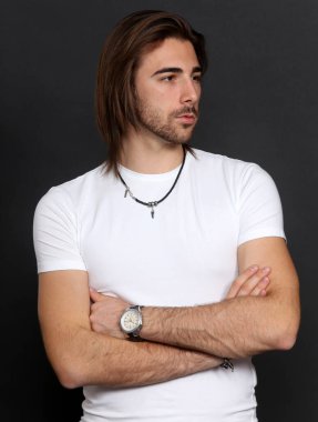 Uzun saçlı ve sakallı çekici erkek model izole bir arka planda stüdyoda poz veriyor. Tarz, trendler, moda konsepti.