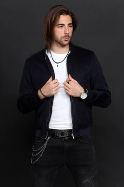 Uzun saçlı ve sakallı çekici erkek model izole bir arka planda stüdyoda poz veriyor. Tarz, trendler, moda konsepti.