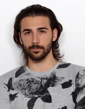 Uzun saçlı ve sakallı çekici erkek model izole bir arka planda stüdyoda poz veriyor. Tarz, trendler, moda konsepti.