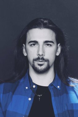 Uzun saçlı ve sakallı çekici erkek model izole bir arka planda stüdyoda poz veriyor. Tarz, trendler, moda konsepti.