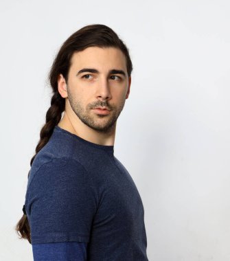 Uzun saçlı ve sakallı çekici erkek model stüdyoda poz veriyor. Tarz, trendler, moda konsepti.