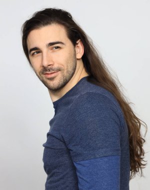 Uzun saçlı ve sakallı çekici erkek model stüdyoda poz veriyor. Tarz, trendler, moda konsepti.