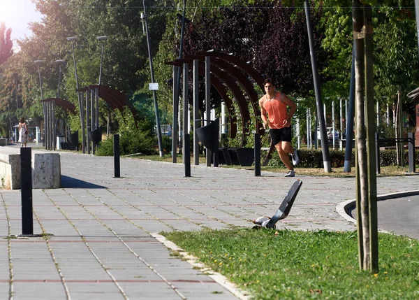 Young male athlete running by the Danube river at quay in Novi Sad, Serbia. Portrait of a runner. Healthy lifestyle, outdoor running, sports concept.