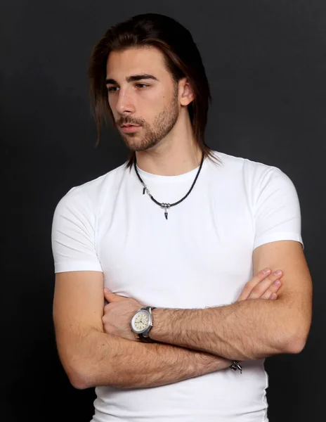 Attractive male model with long hair and beard posing in studio on isolated background. Style, trends, fashion concept.