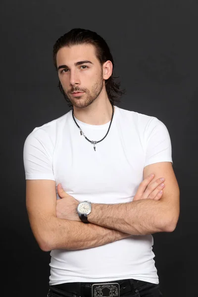 Attractive male model with long hair and beard posing in studio on isolated background. Style, trends, fashion concept.