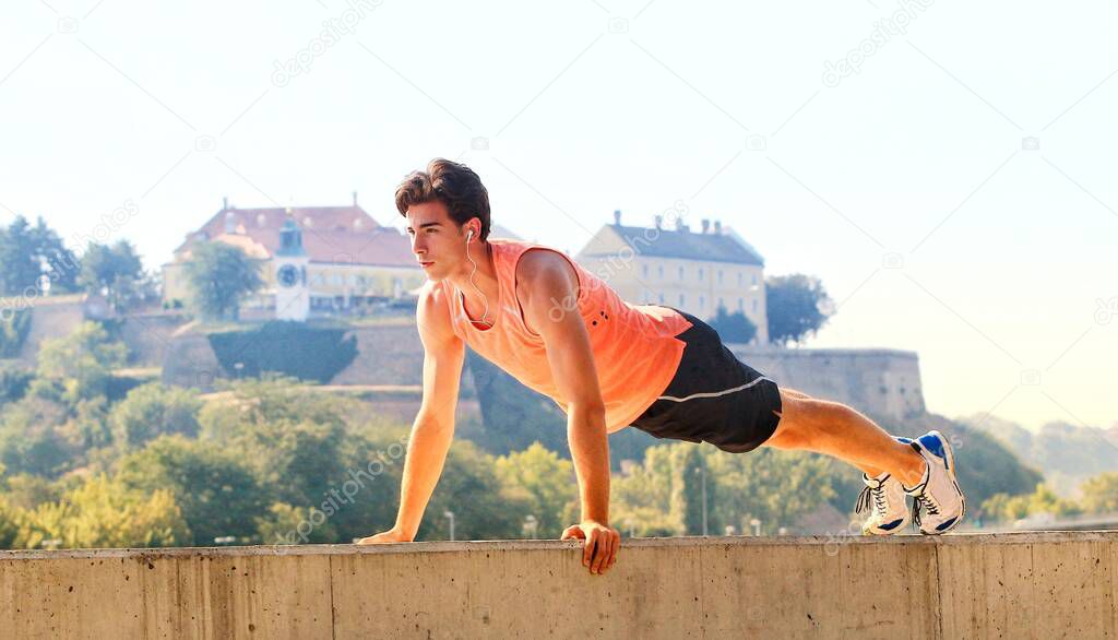 Young male athlete exercising by the Danube river at quay in Novi Sad, Serbia. Healthy lifestyle, outdoor running, sports concept.