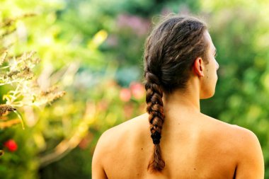 Çok uzun saçlı çekici bir adam vahşi doğada poz veriyor. Modelleme ve Moda Konsepti.