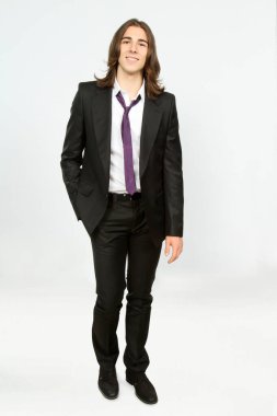 Uzun saçlı, çekici bir erkek model. Stüdyoda poz veriyor. Tarz, trendler, moda konsepti.