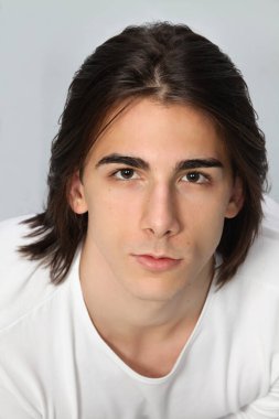 Uzun saçlı, çekici bir erkek model. Stüdyoda poz veriyor. Tarz, trendler, moda konsepti.