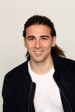 Uzun saçlı, çekici bir erkek model. Stüdyoda poz veriyor. Tarz, trendler, moda konsepti.