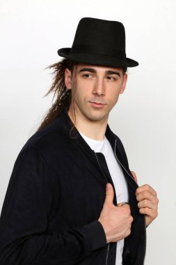 Uzun saçlı, çekici bir erkek model. Stüdyoda poz veriyor. Tarz, trendler, moda konsepti.