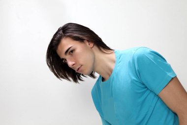 Uzun saçlı, çekici bir erkek model. Stüdyoda poz veriyor. Tarz, trendler, moda konsepti.