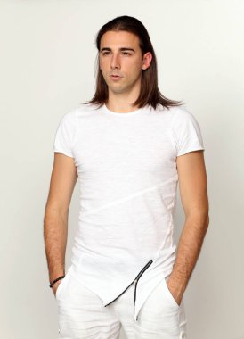 Uzun saçlı, çekici bir erkek model. Stüdyoda poz veriyor. Tarz, trendler, moda konsepti.