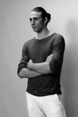 Uzun saçlı, çekici bir erkek model. Stüdyoda poz veriyor. Tarz, trendler, moda konsepti.