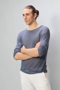 Uzun saçlı, çekici bir erkek model. Stüdyoda poz veriyor. Tarz, trendler, moda konsepti.