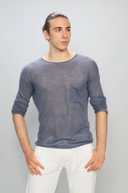 Uzun saçlı, çekici bir erkek model. Stüdyoda poz veriyor. Tarz, trendler, moda konsepti.