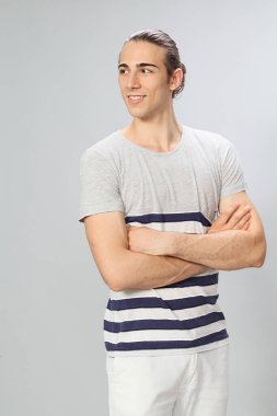 Uzun saçlı, çekici bir erkek model. Stüdyoda poz veriyor. Tarz, trendler, moda konsepti.