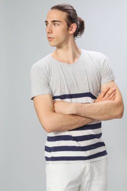 Uzun saçlı, çekici bir erkek model. Stüdyoda poz veriyor. Tarz, trendler, moda konsepti.