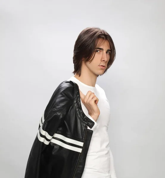 Attractive male model with long hair posing in studio on isolated background. Style, trends, fashion concept.
