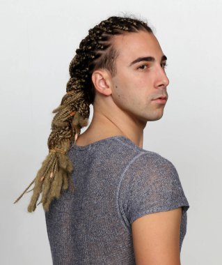 Attractive blonde male model with combination of braids and dreadlocks posing in studio on isolated background. Style, trends, fashion concept. clipart