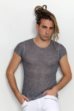 Çekici sarışın erkek model. Örgü ve rastalı saç örgülerinin kombinasyonu. Stüdyoda izole edilmiş arka planda poz veriyor. Tarz, trendler, moda konsepti.