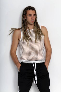 Çekici sarışın erkek model. Örgü ve rastalı saç örgülerinin kombinasyonu. Stüdyoda izole edilmiş arka planda poz veriyor. Tarz, trendler, moda konsepti.