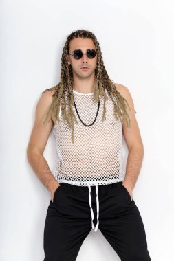 Çekici sarışın erkek model. Örgü ve rastalı saç örgülerinin kombinasyonu. Stüdyoda izole edilmiş arka planda poz veriyor. Tarz, trendler, moda konsepti.