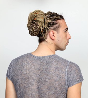 Çekici sarışın erkek model. Örgü ve rastalı saç örgülerinin kombinasyonu. Stüdyoda izole edilmiş arka planda poz veriyor. Tarz, trendler, moda konsepti.