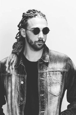 Çekici sarışın erkek model. Örgü ve rastalı saç örgülerinin kombinasyonu. Stüdyoda izole edilmiş arka planda poz veriyor. Tarz, trendler, moda konsepti.