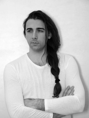 Örgü ören çekici genç adam içeride poz veriyor. Tarz, trendler, moda konsepti.