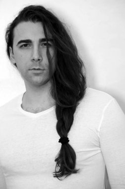 Örgü ören çekici genç adam içeride poz veriyor. Tarz, trendler, moda konsepti.