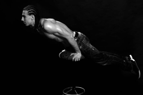 Attractive male model with plaits is posing in studio on isolated background. Style, trends, fashion concept.