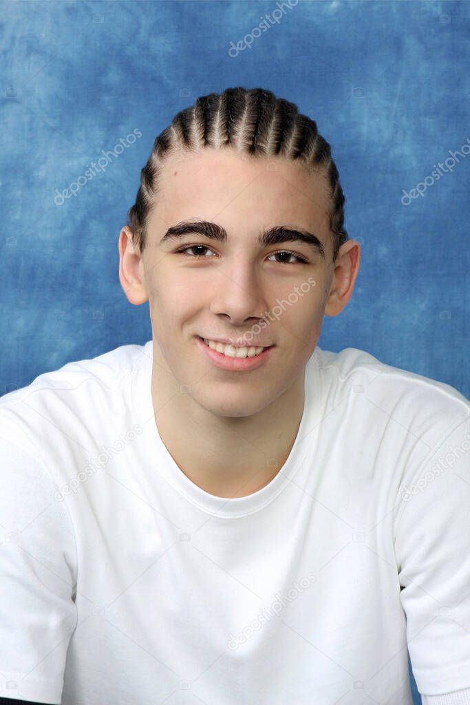 Attractive young child with plaits is posing in studio on isolated background. Style, trends, fashion concept.