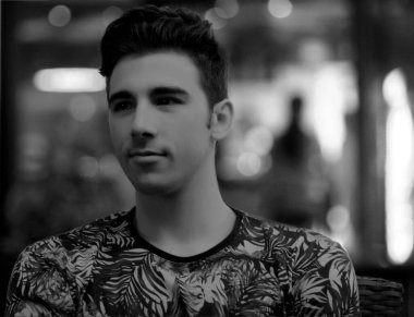 Açık havada poz veren kısa saçlı çekici erkek model. Tarz, trendler, moda konsepti.