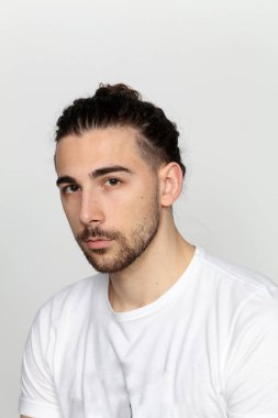 Uzun saçlı ve sakallı çekici erkek model izole bir arka planda stüdyoda poz veriyor. Tarz, trendler, moda konsepti.