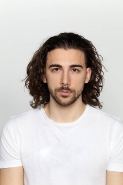 Uzun saçlı ve sakallı çekici erkek model izole bir arka planda stüdyoda poz veriyor. Tarz, trendler, moda konsepti.