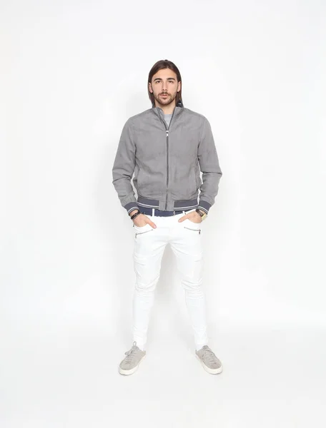Uzun saçlı ve sakallı çekici erkek model izole bir arka planda stüdyoda poz veriyor. Tarz, trendler, moda konsepti.